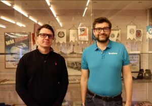 Monimetalliyhtiö Terrafame tulee mukaan Vuokatti-Jukolan osuuskumppaniksi. Kuvassa kaksi miestä lasisen palkintokaapin edessä. Vasemmalla Vuokatti Sportin toimitusjohtaja Kosti Puurunen ja hänen vierellään oikealla Terrafamen toimitusjohtaja Antti Koulumies.